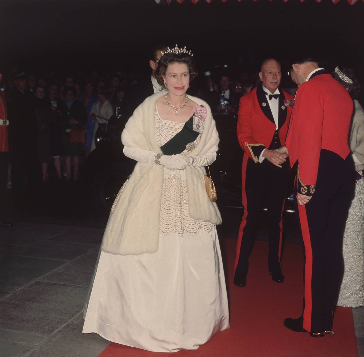 Queen Elizabeth II attends a nighttime movie premiere in 1960.