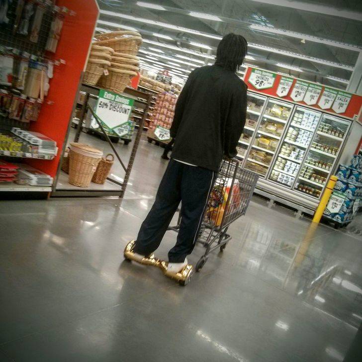 man pushing cart on hoverboard at grocery store