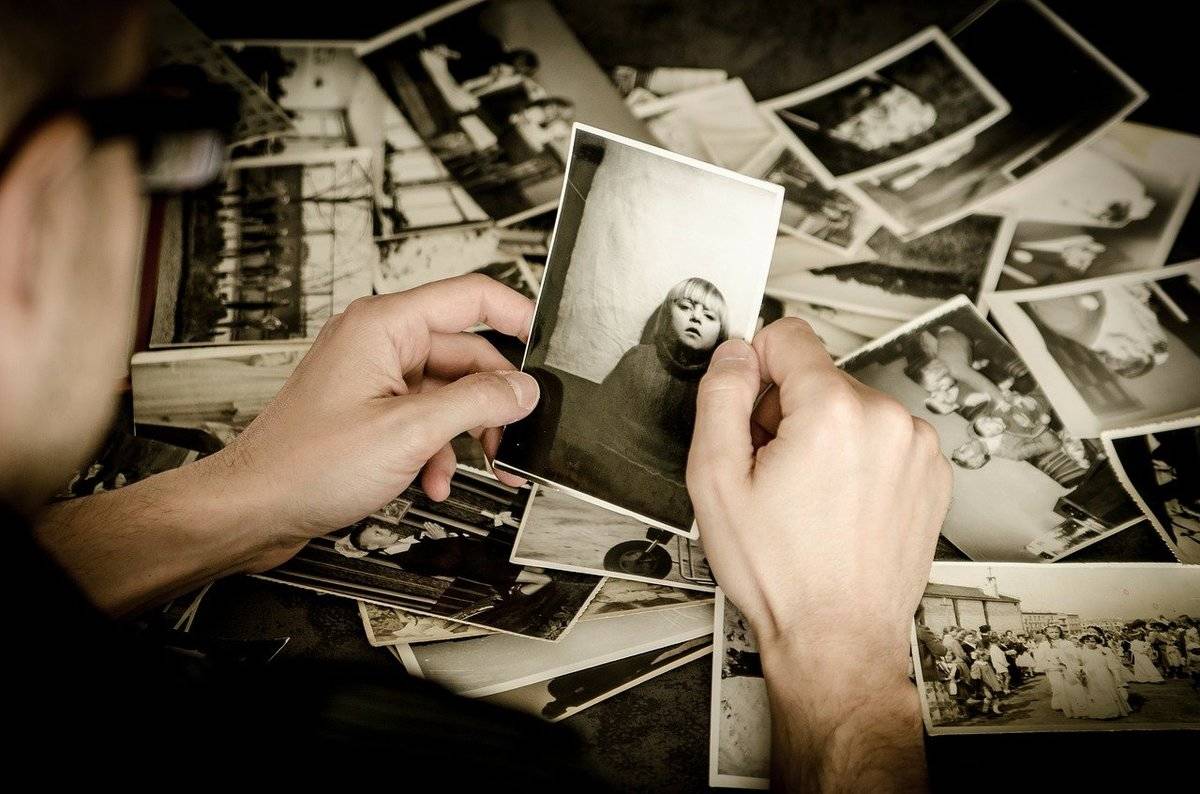 A person looks through old black and white photographs.