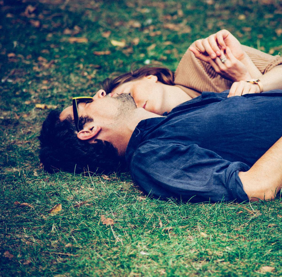 man and woman lying together on the ground