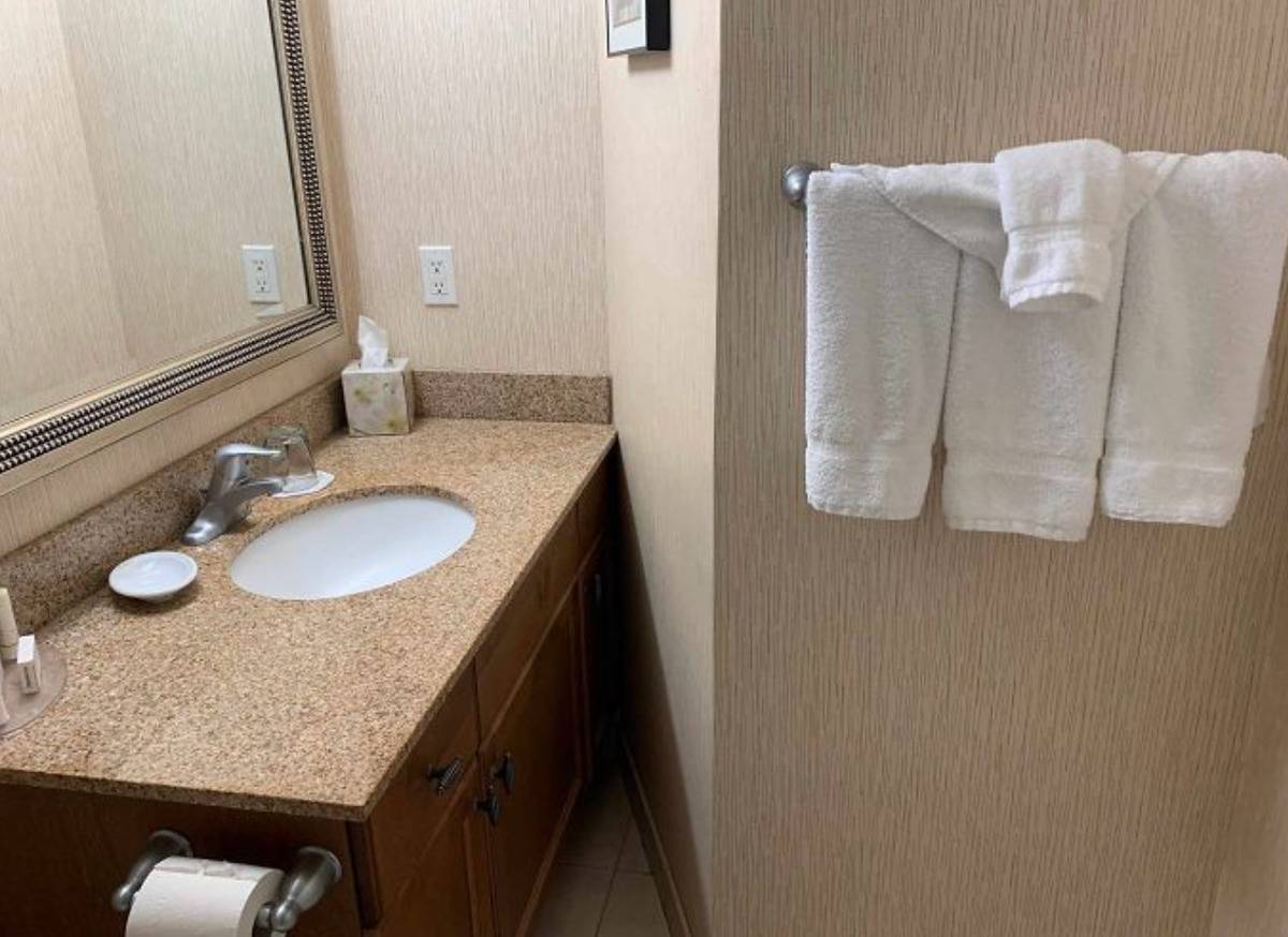 bathroom is designed so that wall blocks people from standing in front of sink