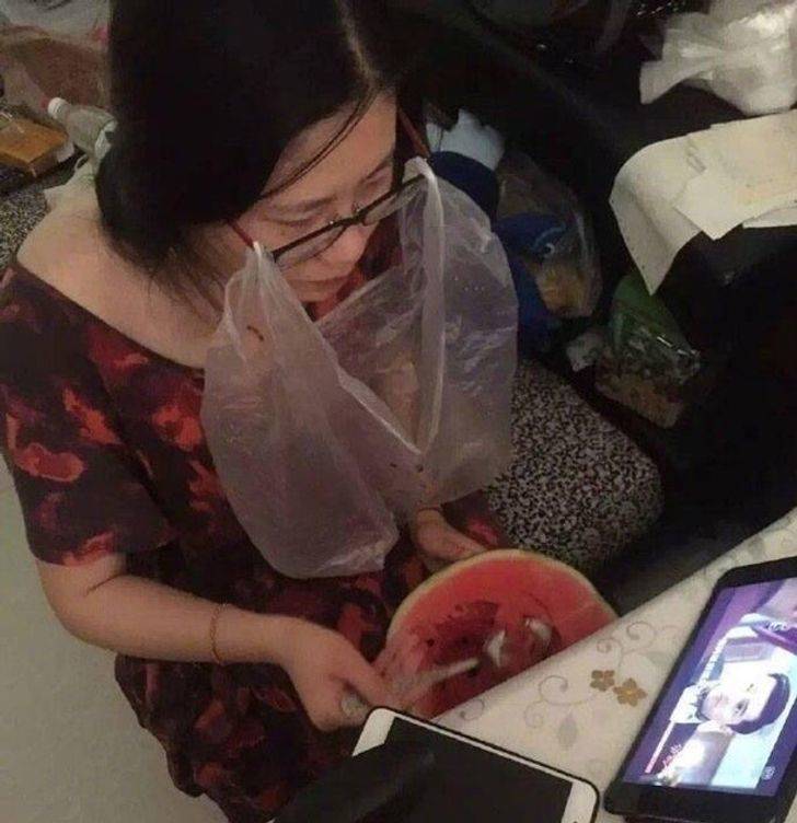 woman eating watermelon spitting the seeds into a bag tied to her glasses