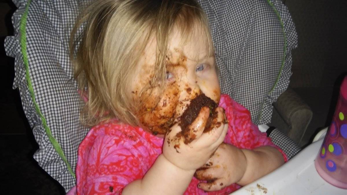 toddler eating cupcake and covered in it