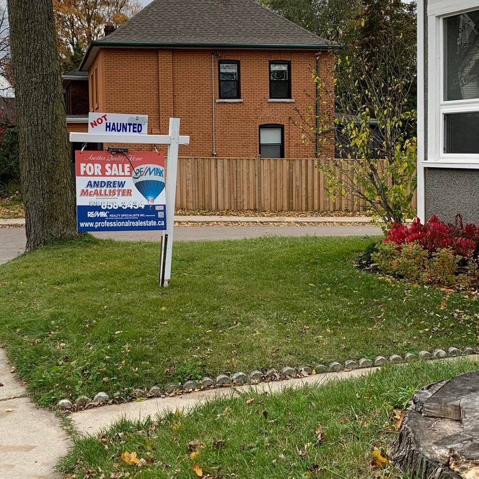 for sale sign next to cemetary