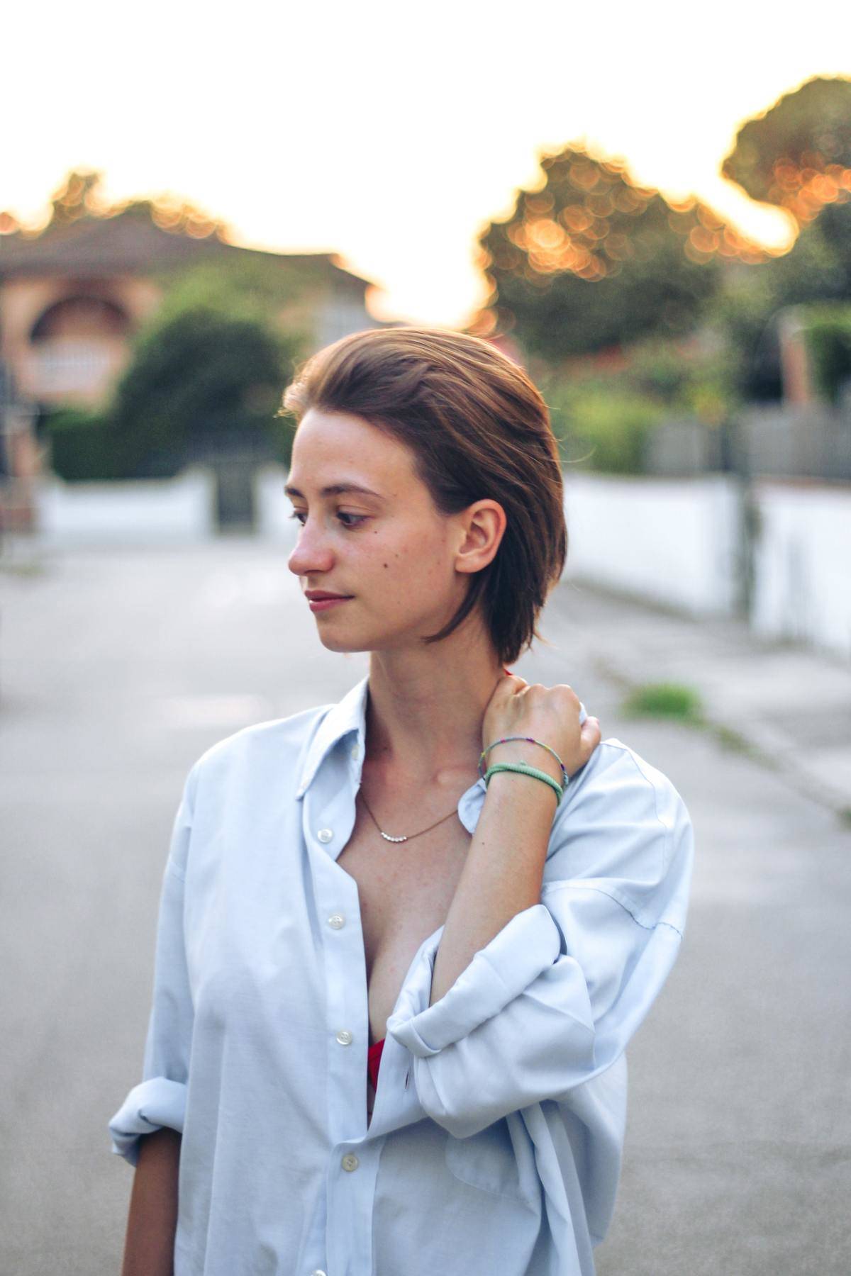 woman holding her shoulder while walking outside