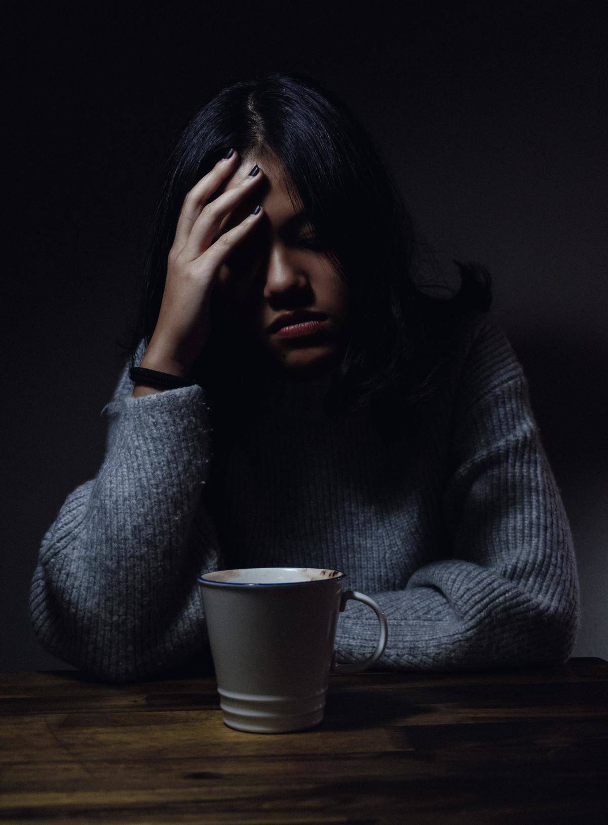 woman rests her head on table