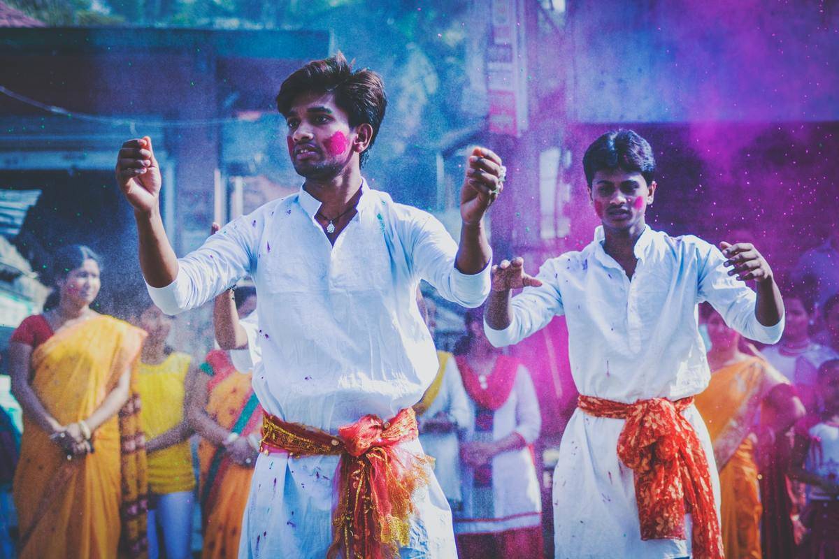 People toss colored chalk into the air during an Indian festival.