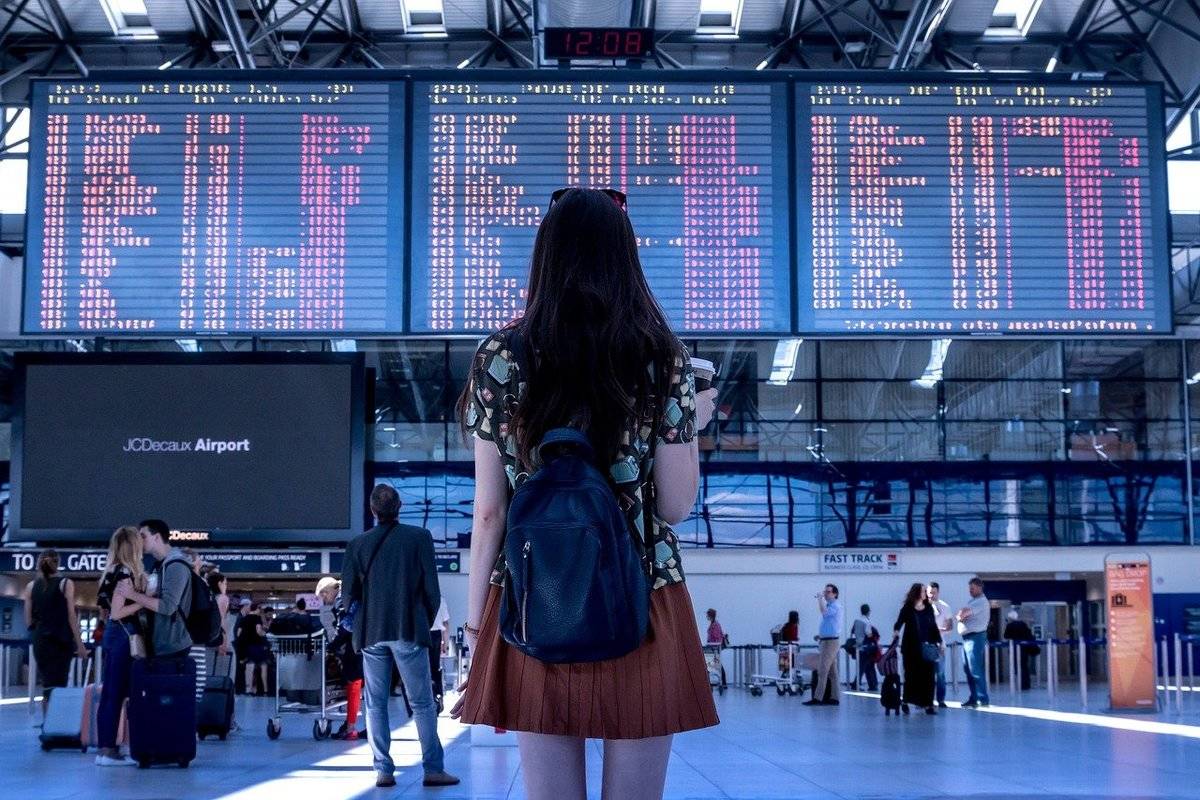 A woman reads airport signs for her terminal.