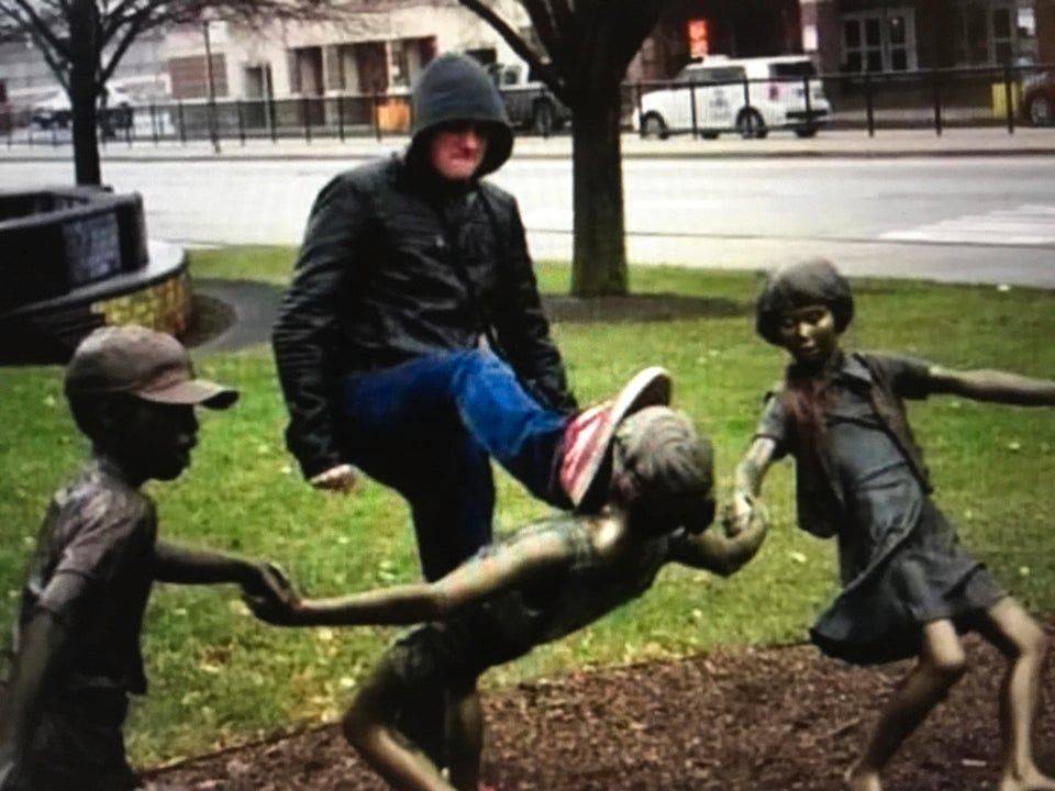 guy angrily kicking child statue in the face