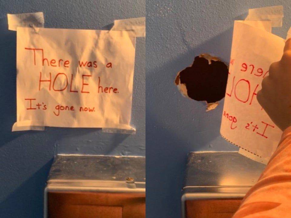 Hole in wall behind sign
