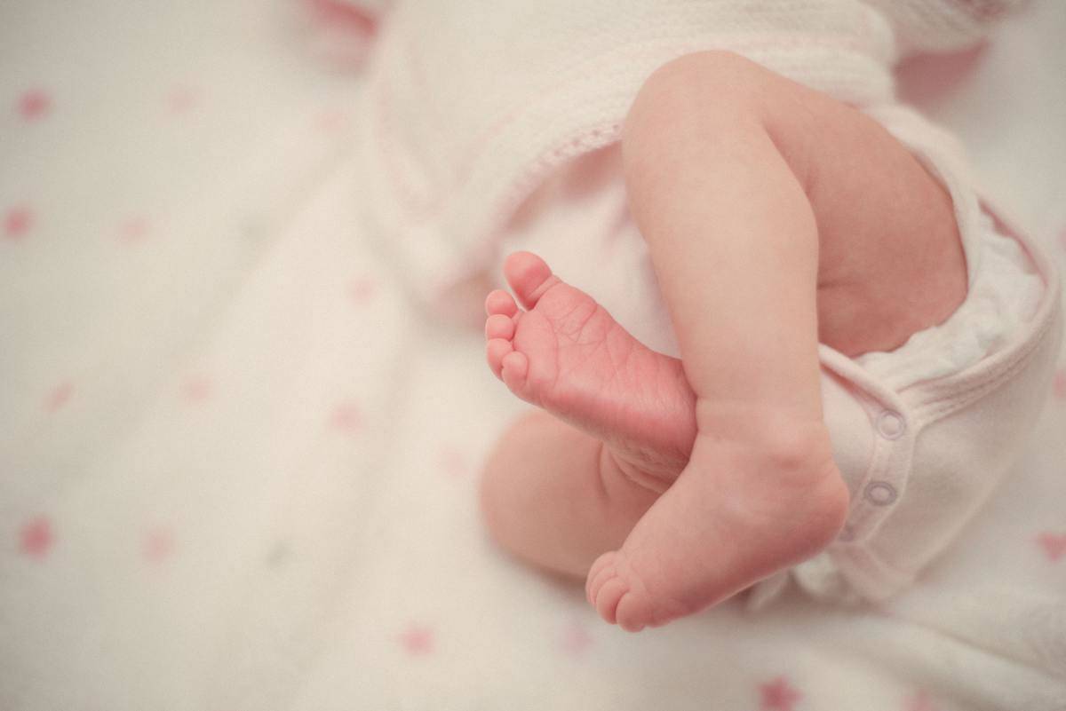 a baby sleeping on a pink dotted blanket 