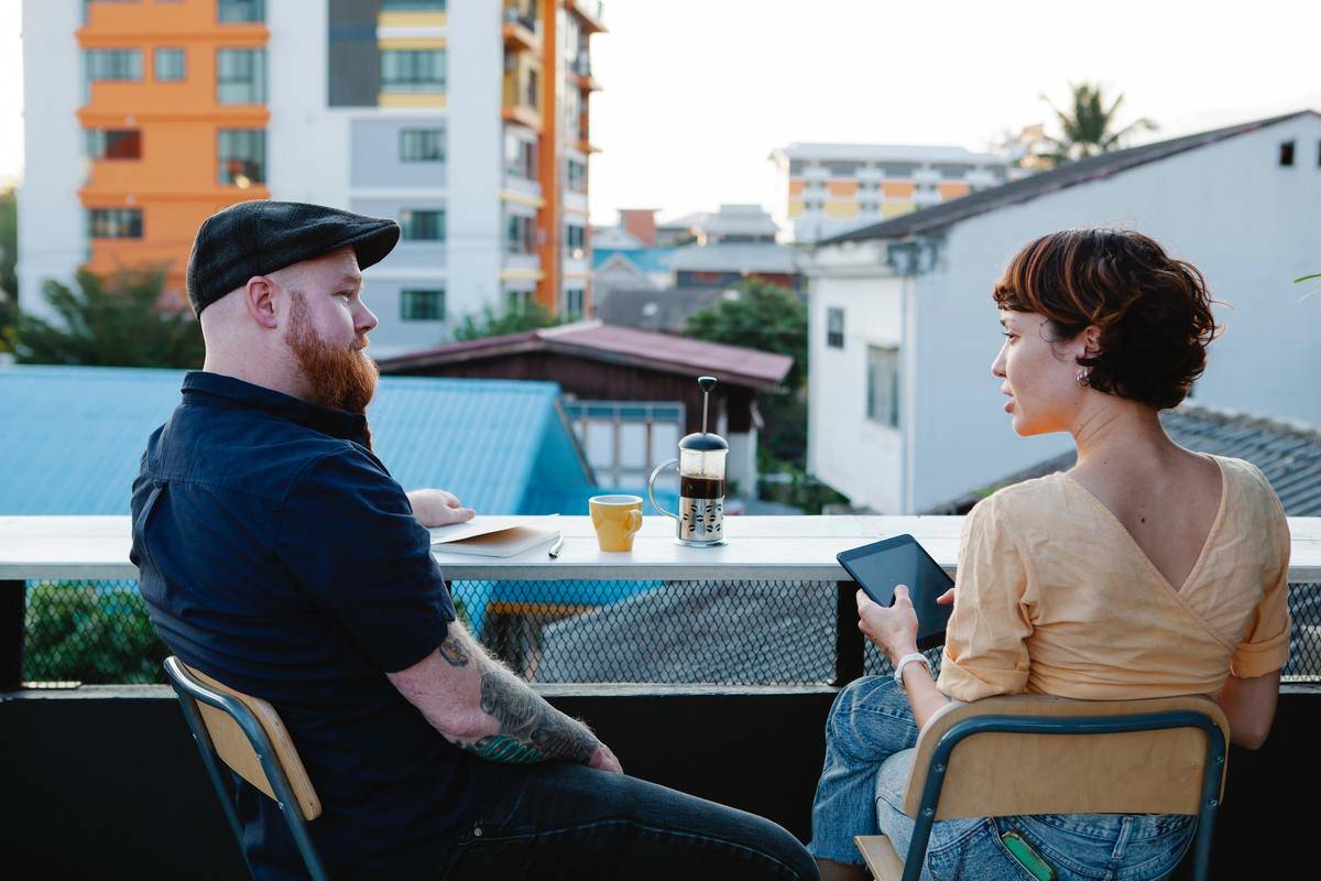 man and woman talking on balcony