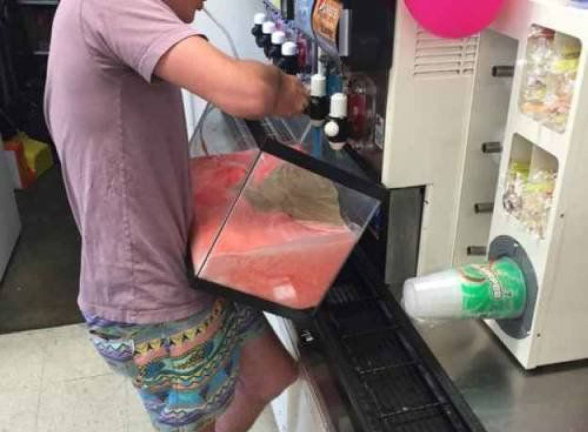 guy filling up empty fish tank with slushy at a store