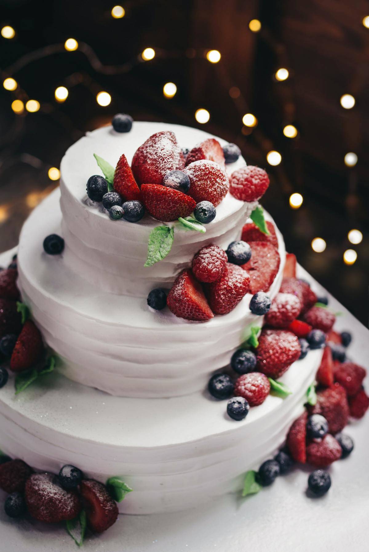 multi-tiered cake covered in berries