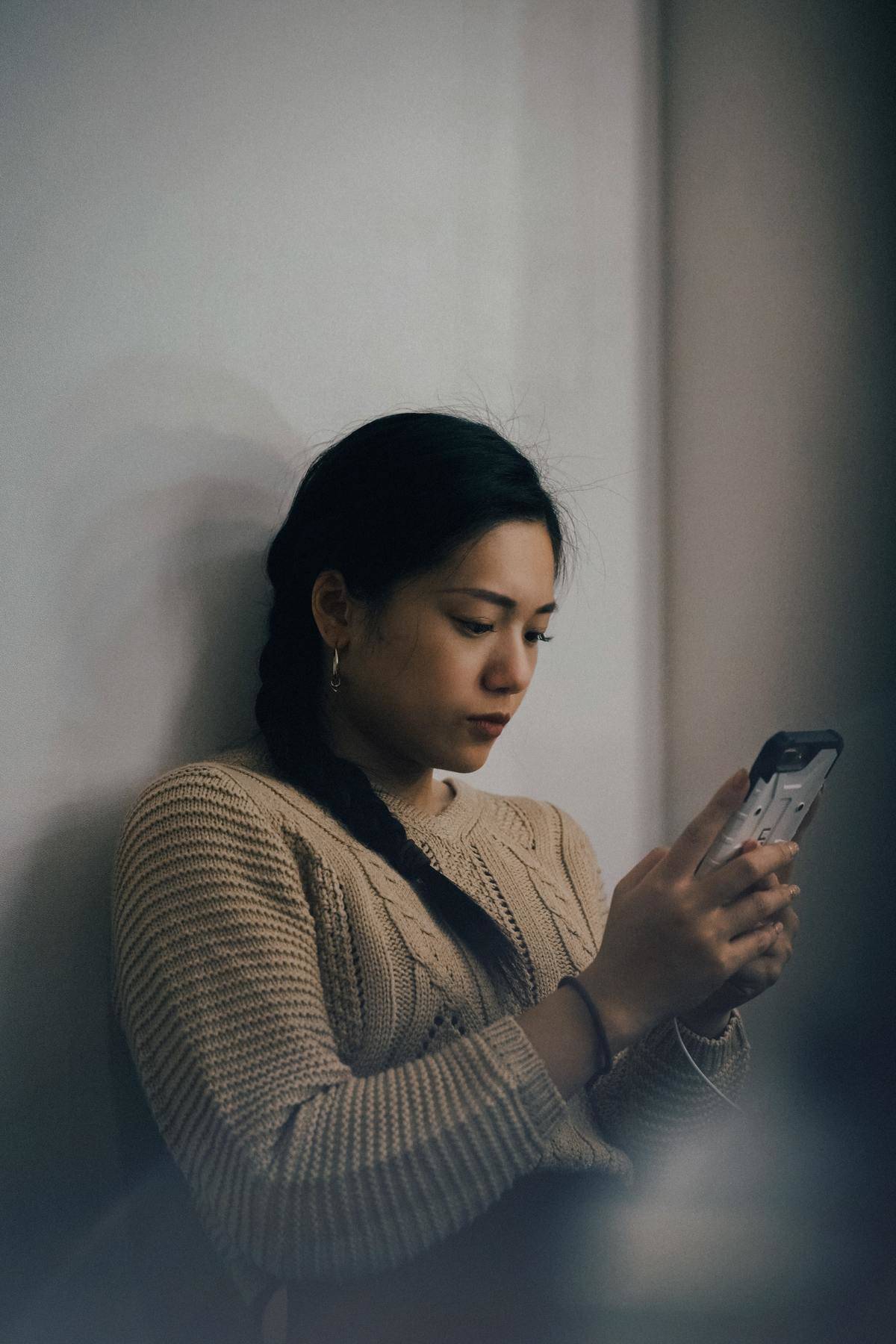 a woman sitting down looking at her phone