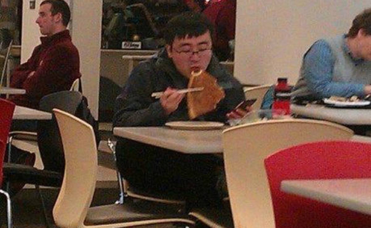 guy eating pizza with chopsticks 