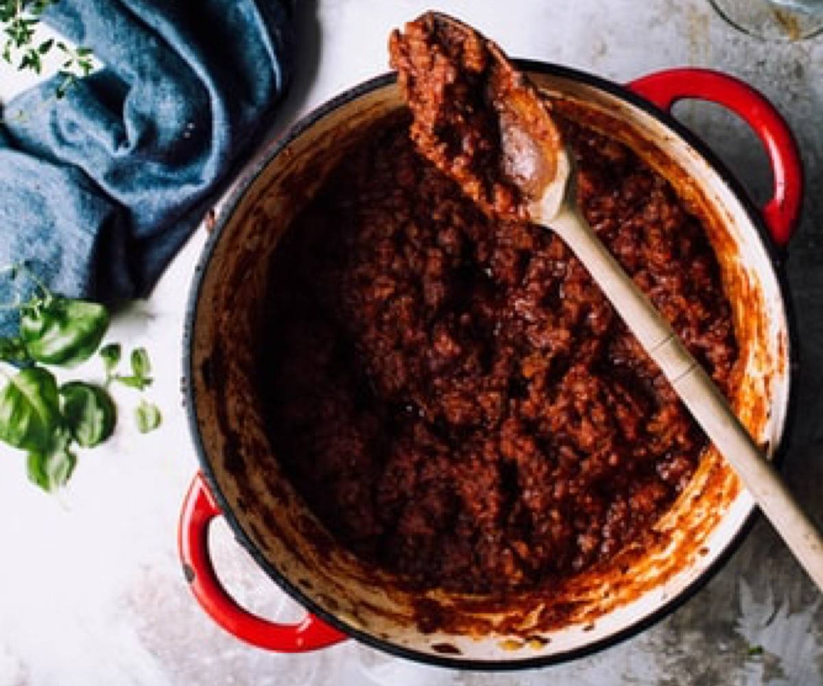 thick tomato sauce with wooden spoon in it