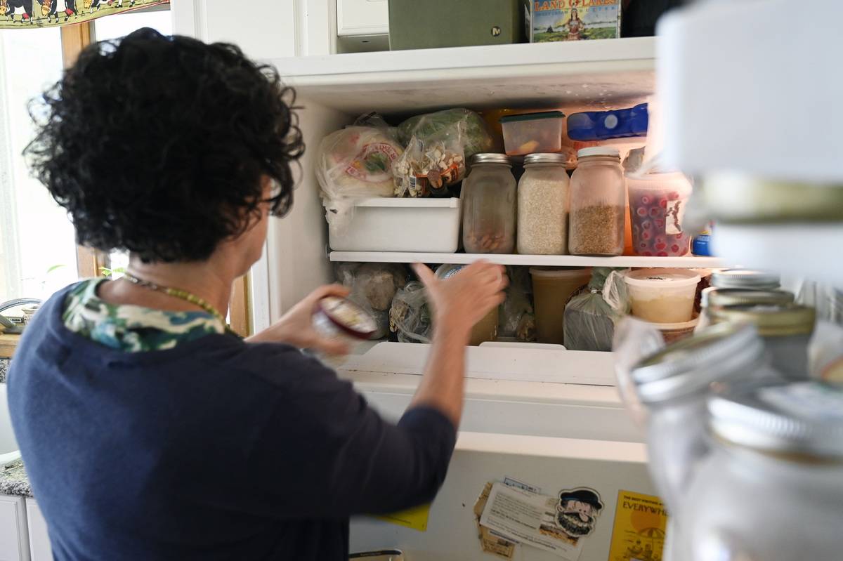 A woman cleans out her refrigerator.