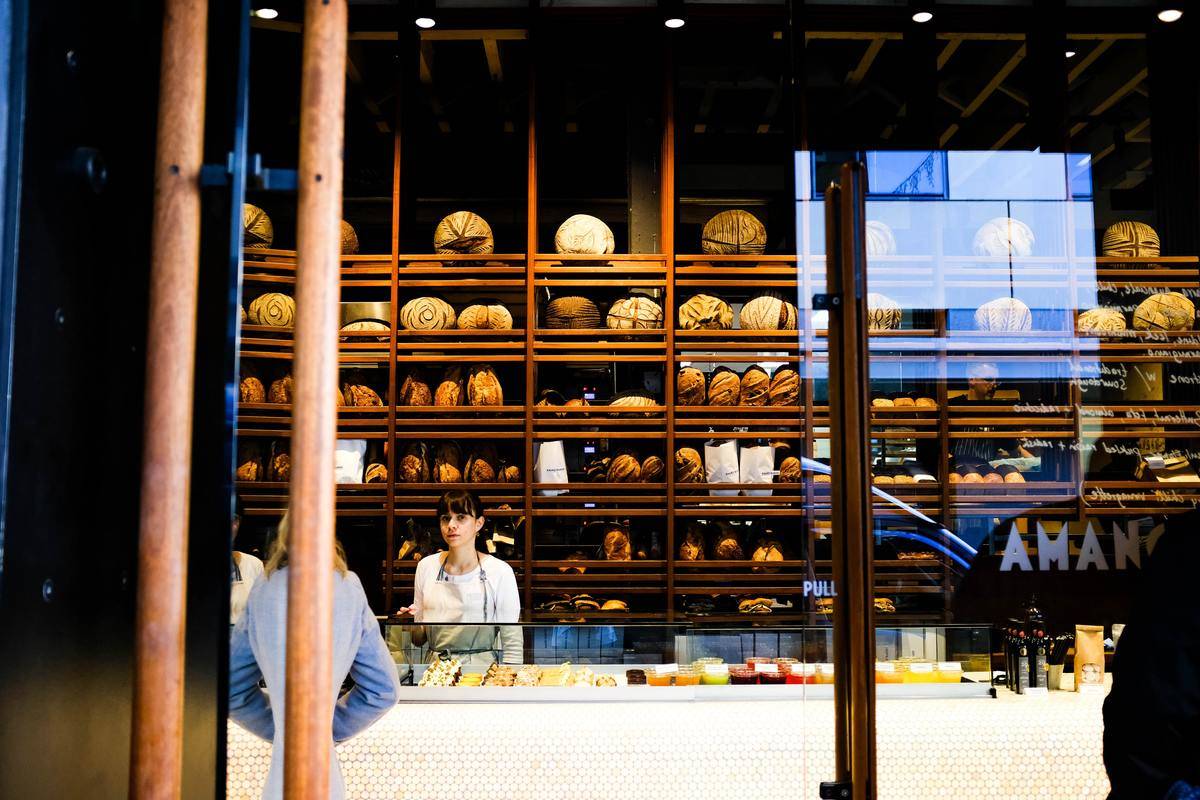 woman at front counter of bakery talking to customer