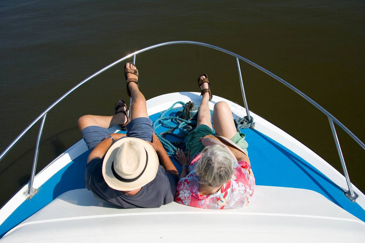 An elderly couple sits on a cruise.