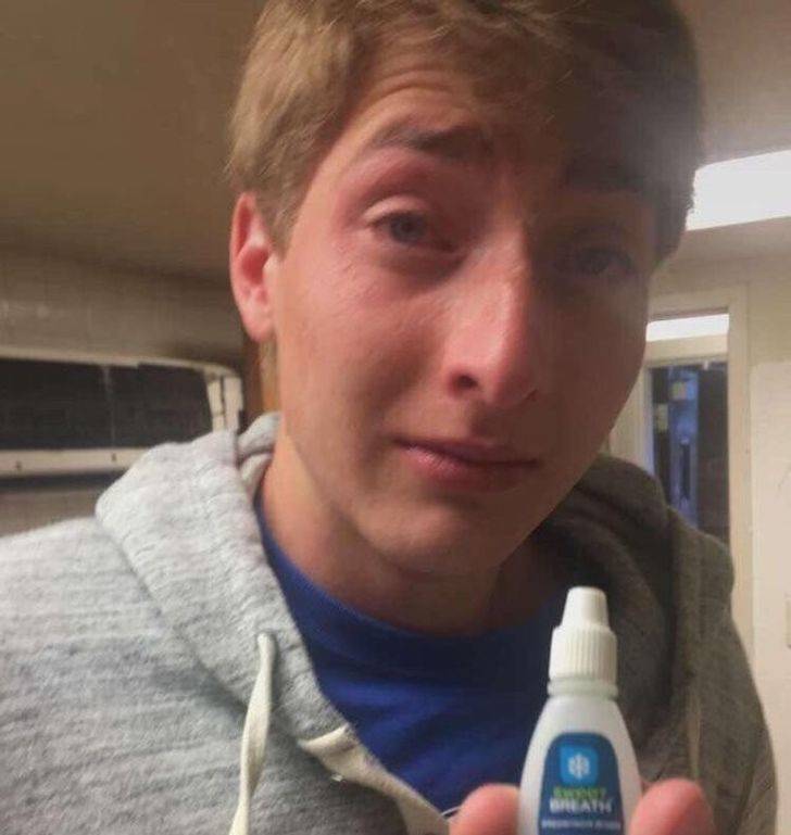 teary-eyed man holding breath drop bottle that looks like eye drop bottle