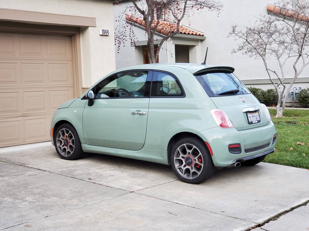 Side view of lime green Fiat 500 automobile parked on a suburban driveway in San Ramon, California, December 26, 2019.