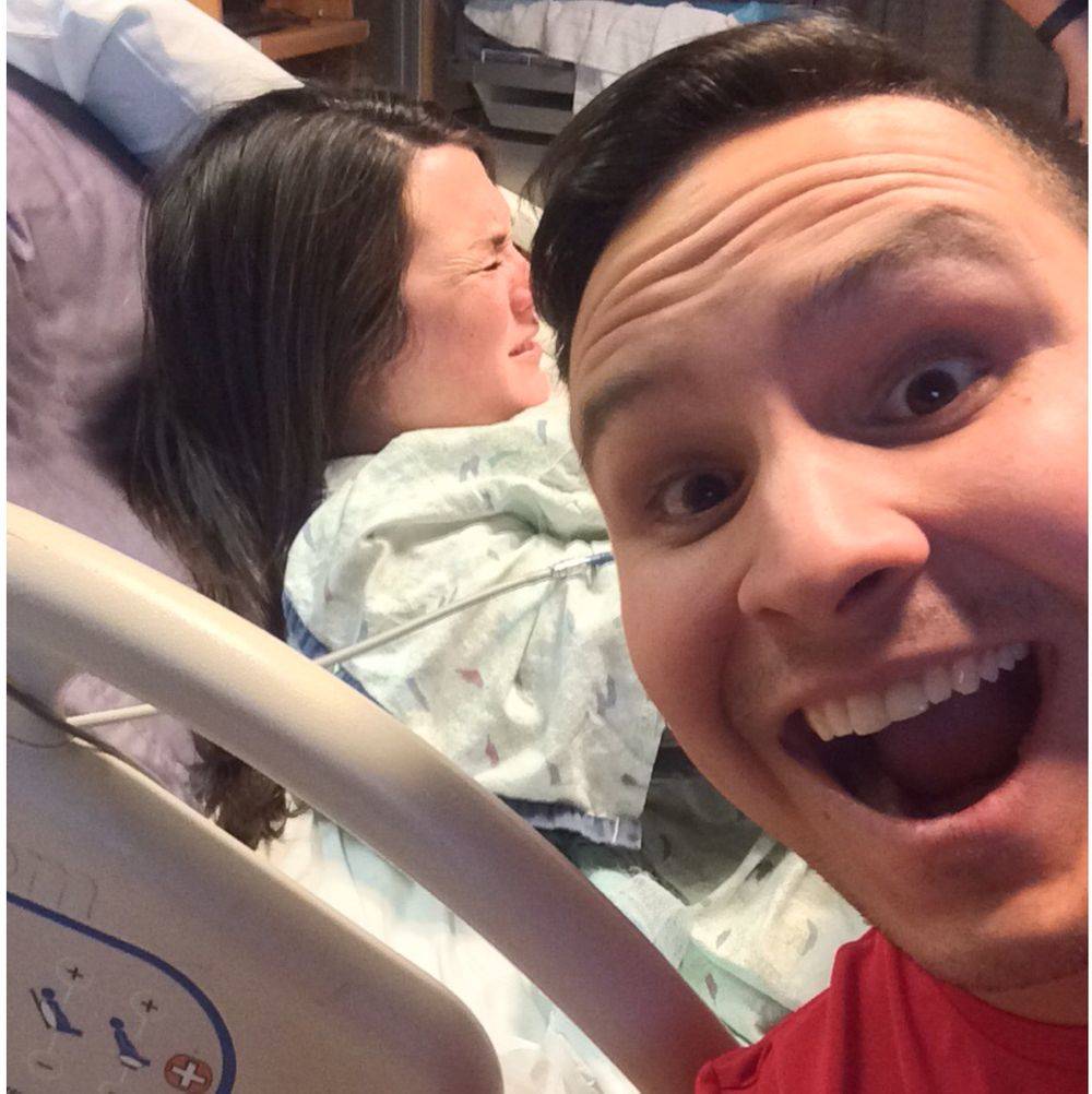man taking happy selfie while his wife's in labor