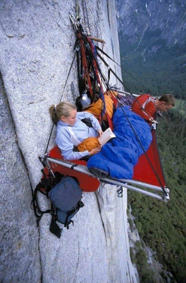 couple camping on cliffside, hanging over the edge