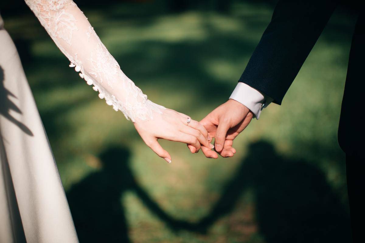 bride and groom loosely holding hands