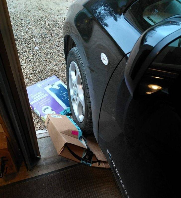 package being crushed by car's front tire as the car leaves the garage