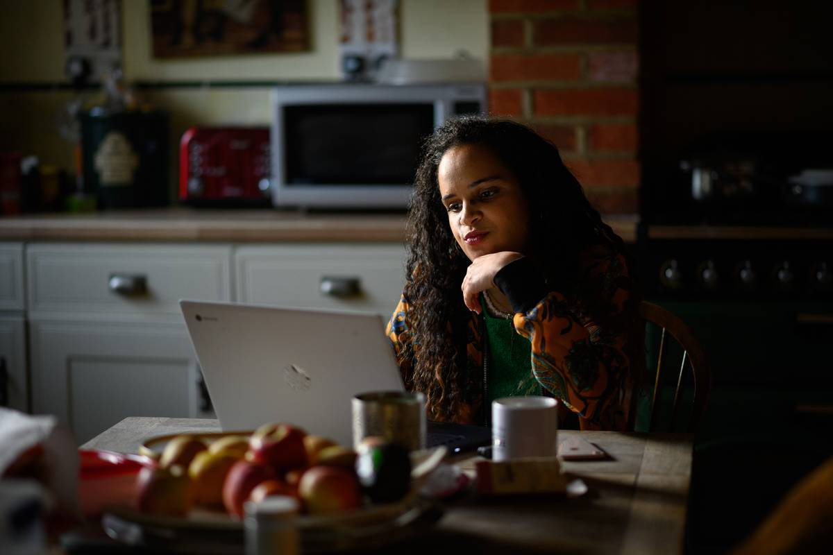 A woman reads something on her laptop.
