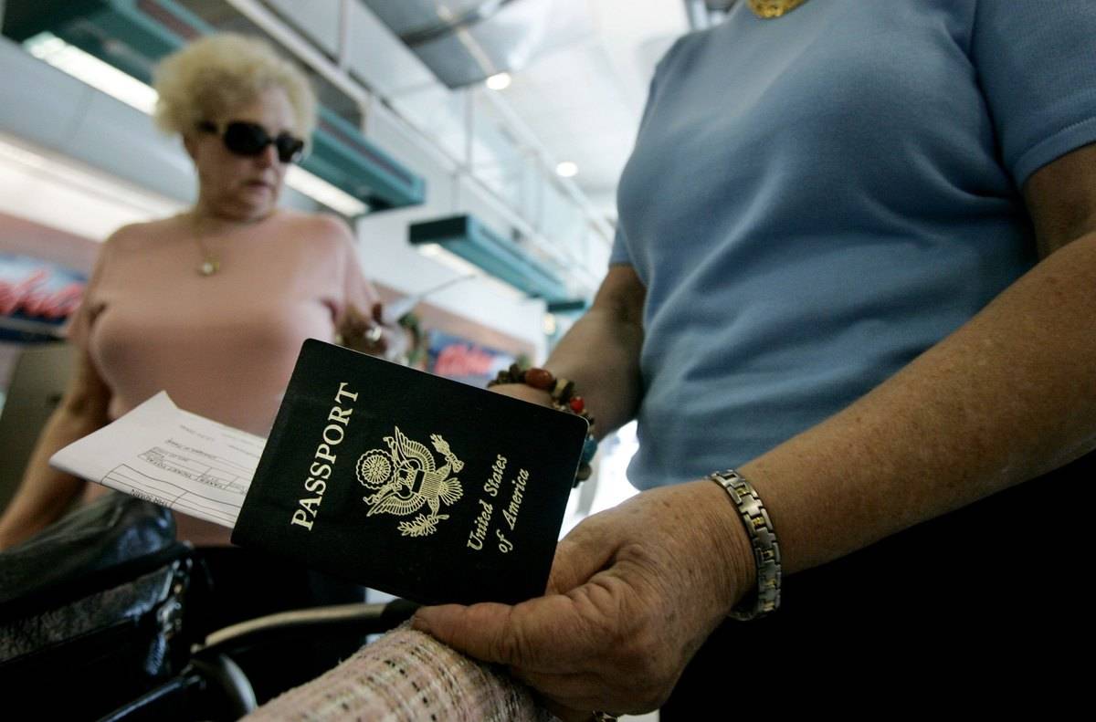 A man checks his passport while in an airport.