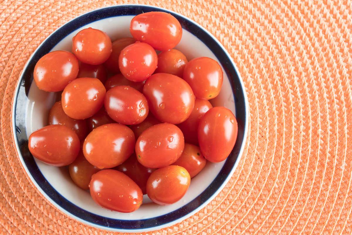 small bowl of red cherry tomatoes on placemat