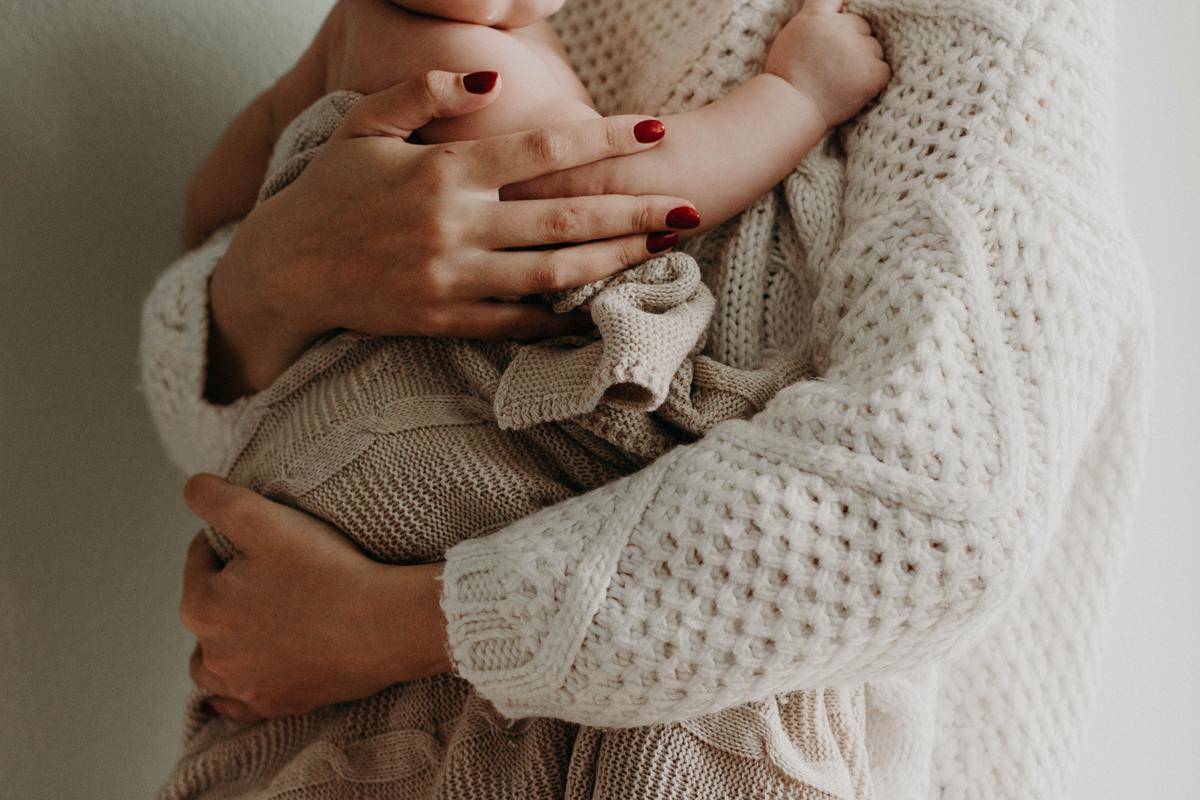 woman holding her baby close to her 