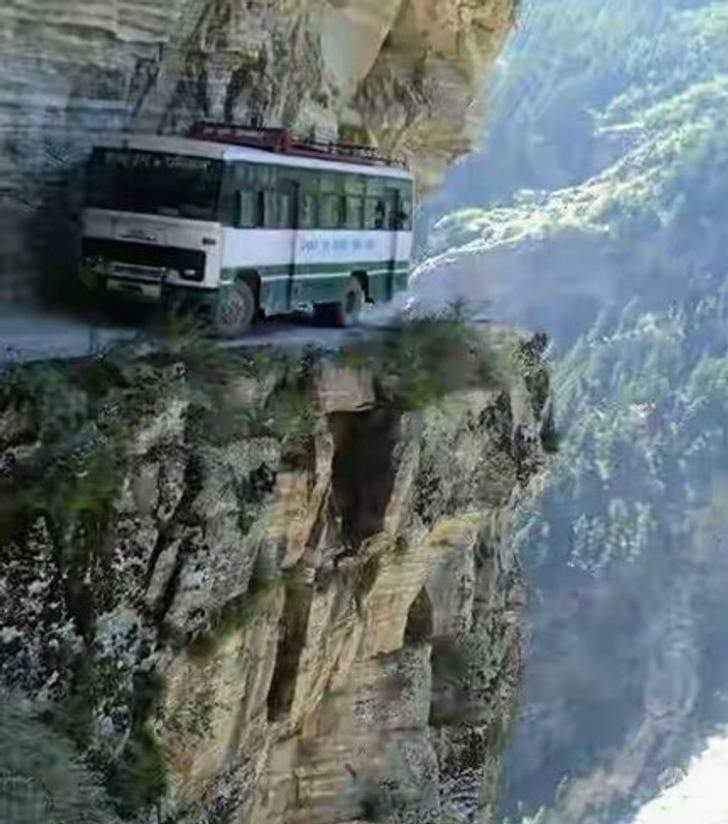 bus on tiny road in the mountains, hugging the cliffside