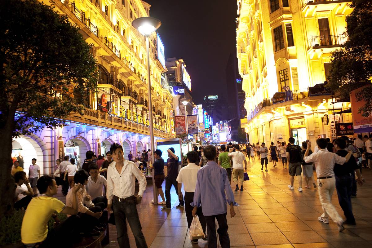 Shoppers walk along Nanjing East Road, a pedestrian street and one of the main shopping districts in Shanghai, China.