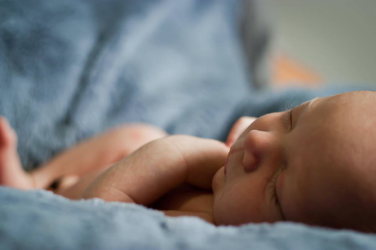a baby sleeping on a blue blanket 