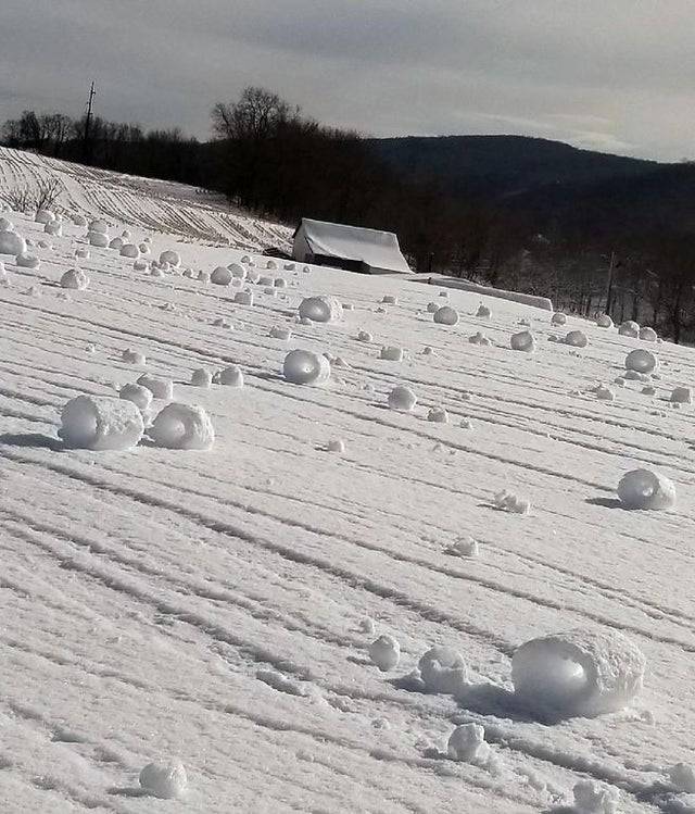 windy day formed rolls of snow on hill