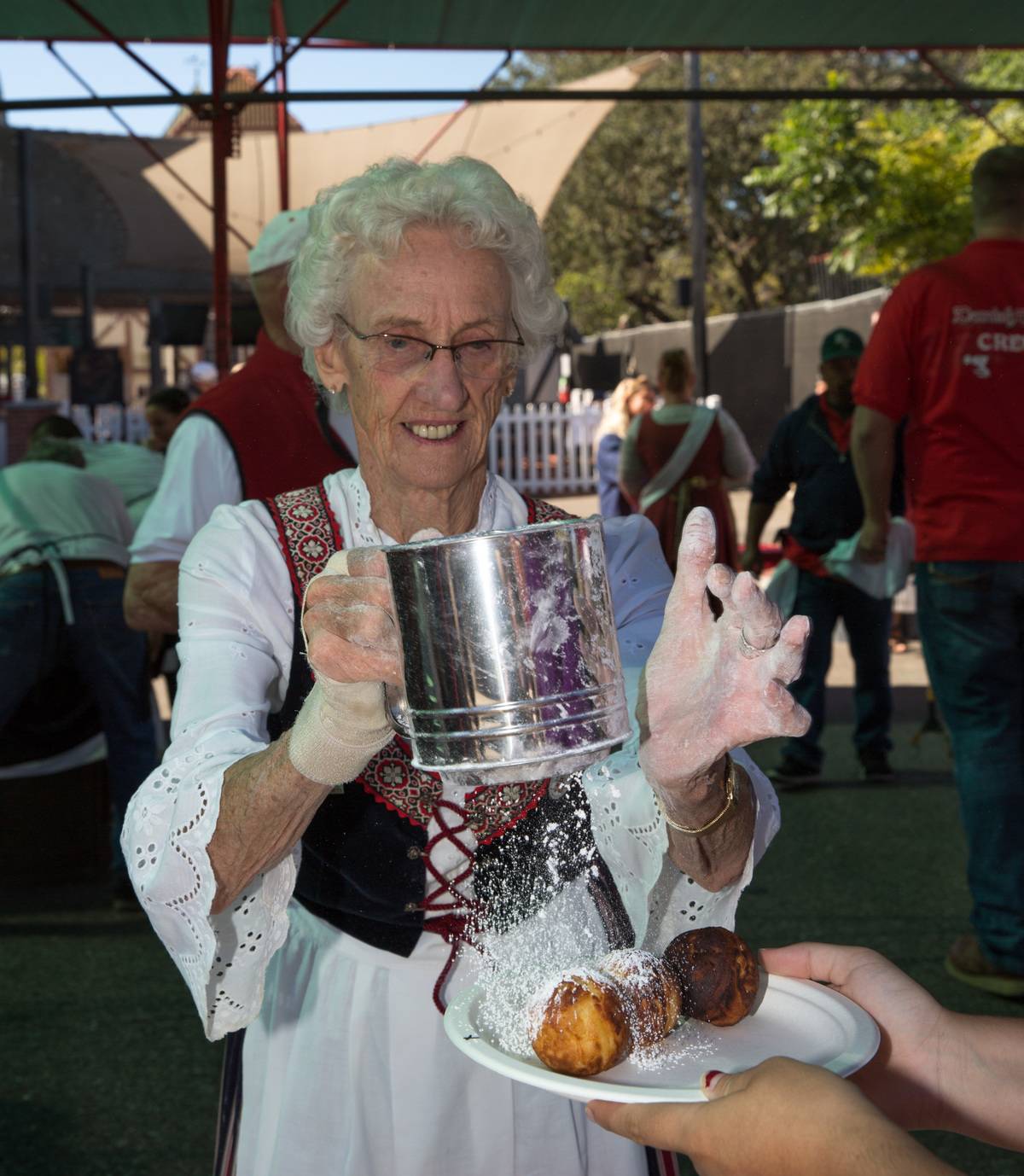 Someone pouring powdered sugar onto a desert