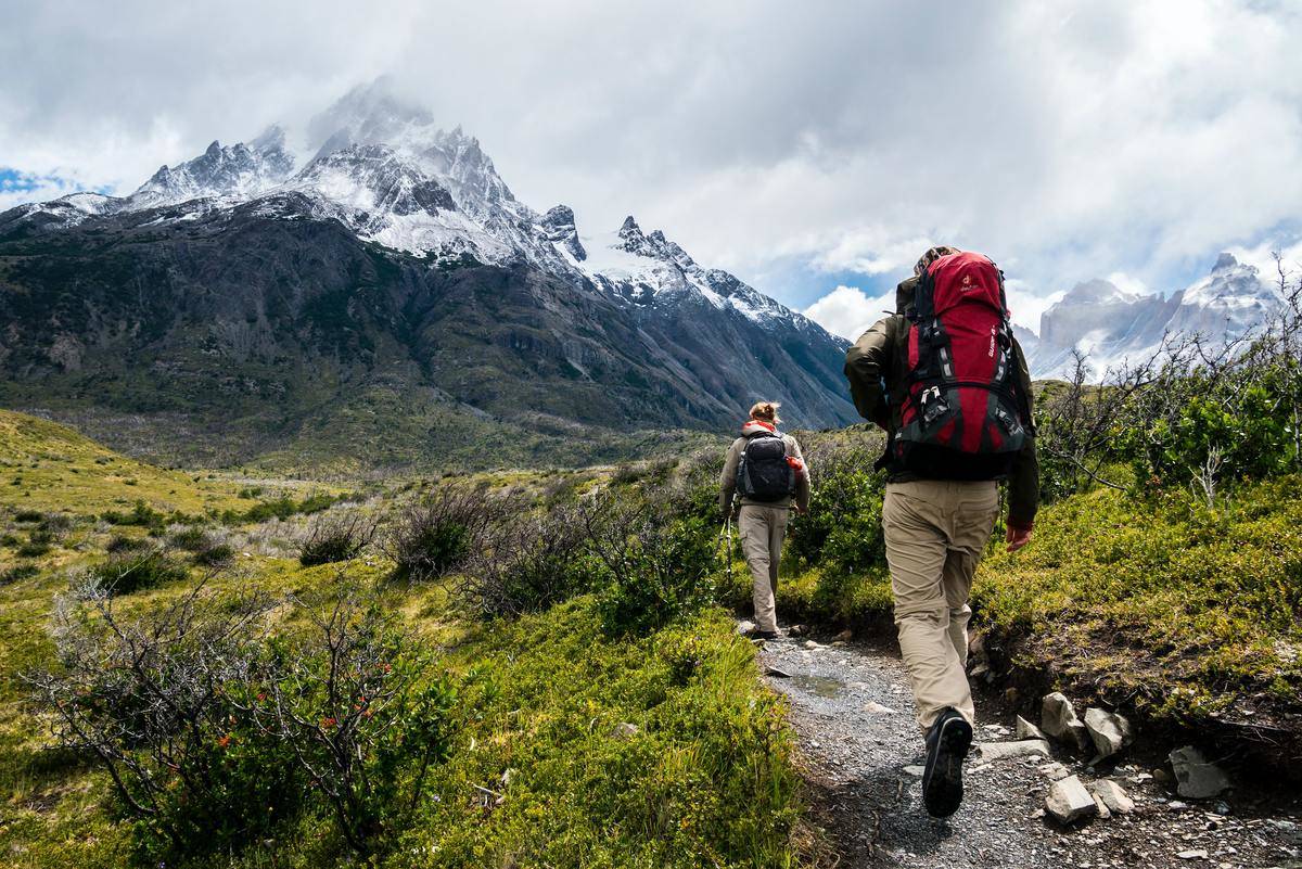 man and woman walk through hiking trail