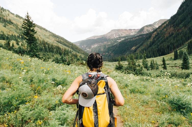 Behind shot of woman hiking with large backpack 