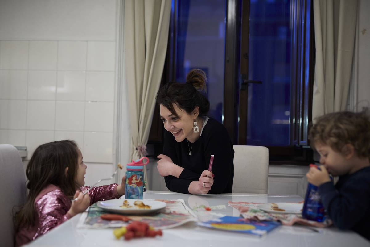 Cristina plays with her children during dinner
