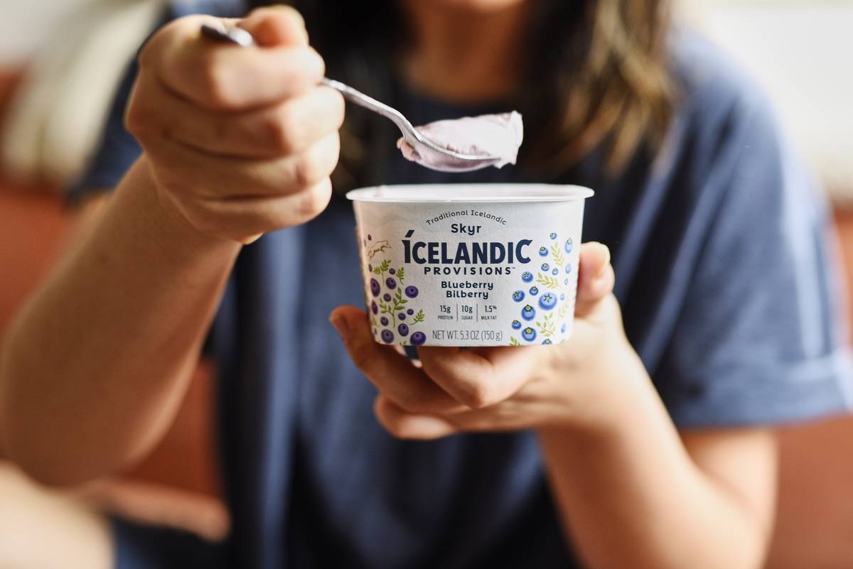 A woman eats Icelandic Greek yogurt.