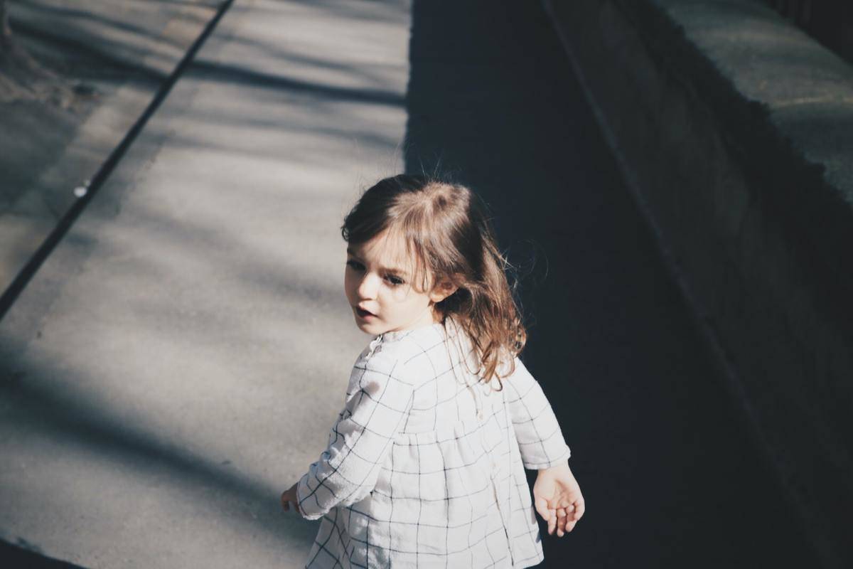 Little girl looking back while walking