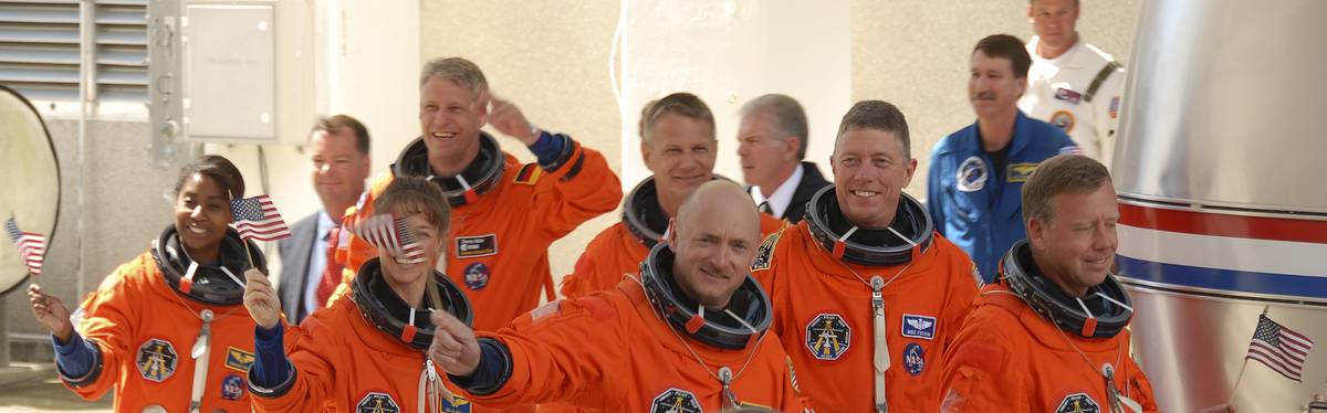 Scott Kelly walks toward a space shuttle with his crew.