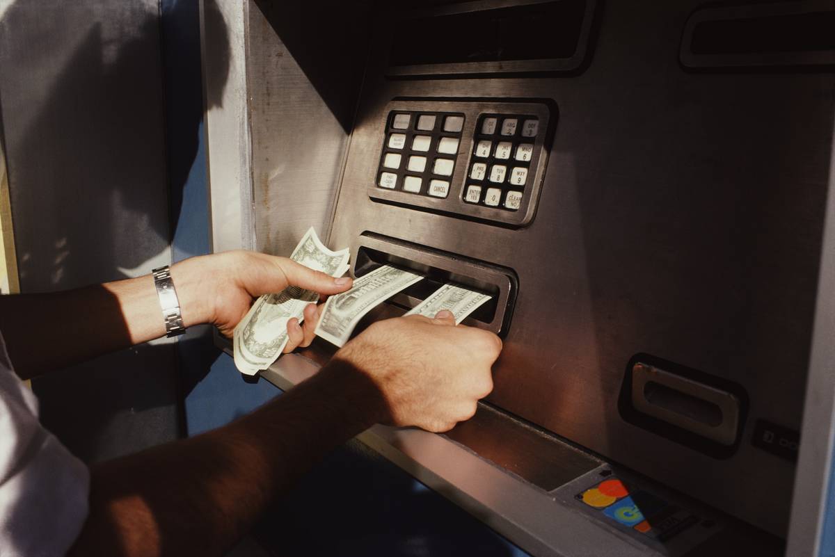 A man receives cash from an atm.