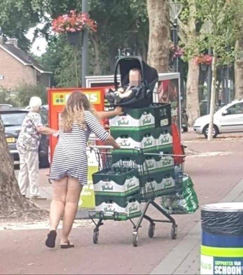 baby in shopping cart on top of beer