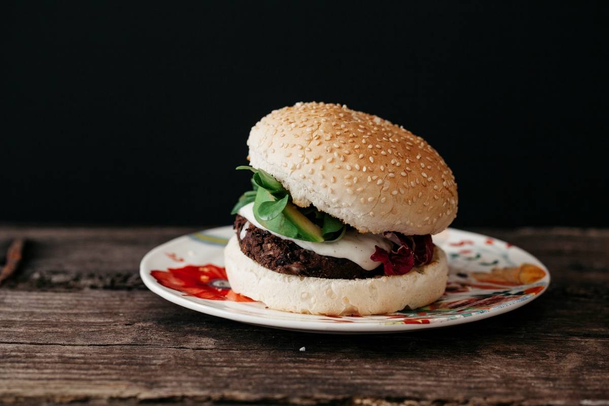A vegan black bean burger sits on a plate.