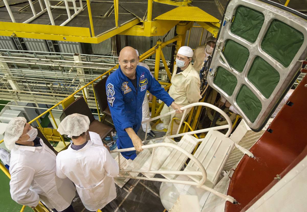 Scott Kelly climbs stairs to enter the Soyuz TMA-16M spacecraft.