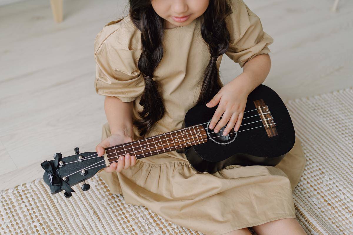 girl sitting with black guitar
